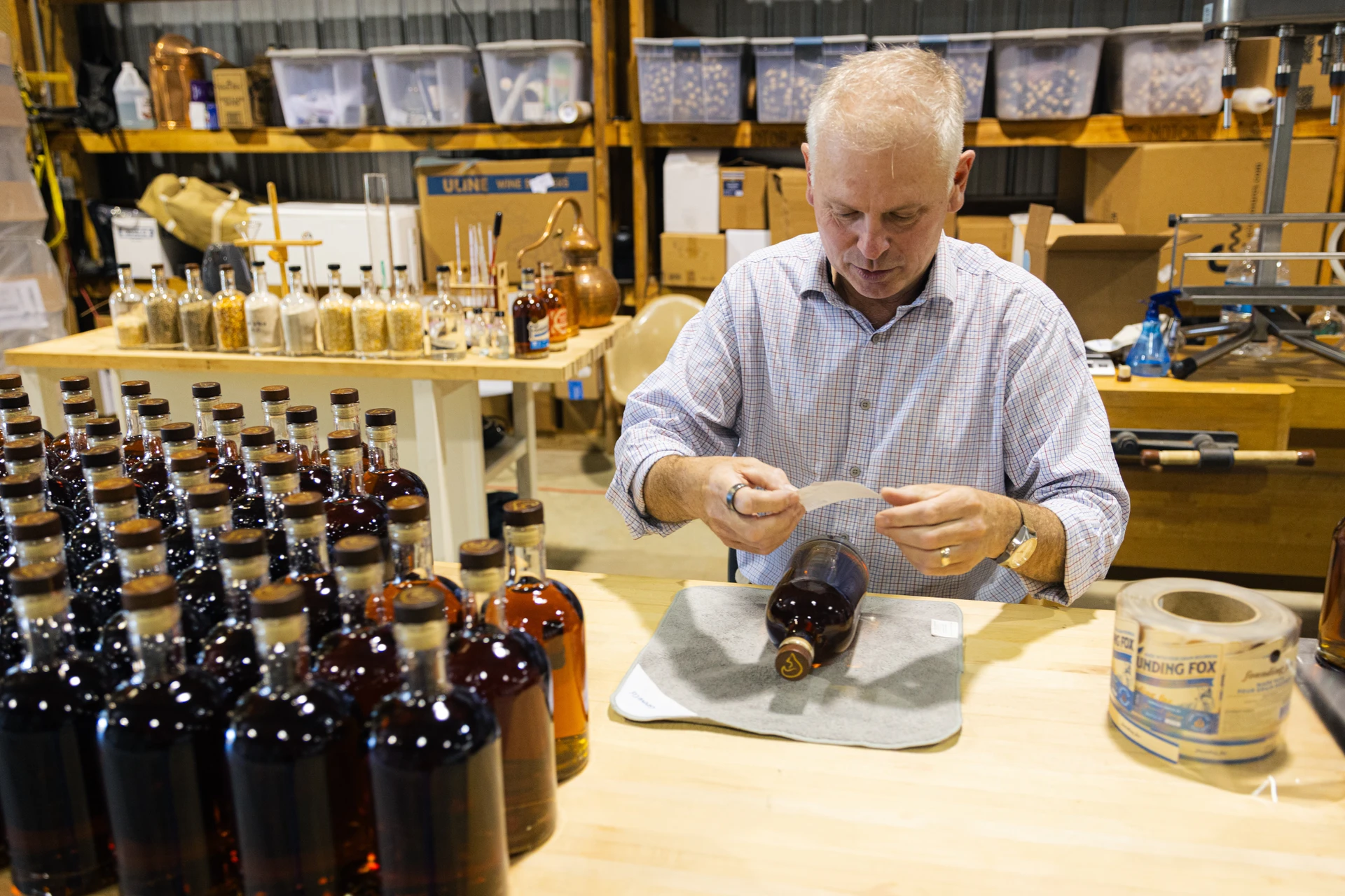 Bottles of Founding Fox Bourbon lined up on a wooden bar at the General George Stillhouse