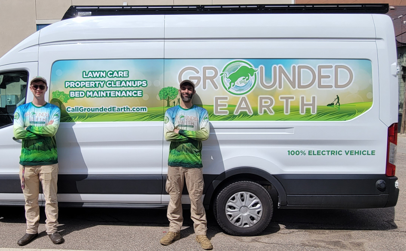 A Grounded Earth crew member loading battery-powered equipment into an electric service vehicle